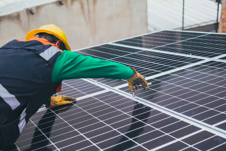 A guy installing solar power source for the inverter